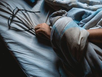 Woman waking at night with carpal tunnel wrist pain and numb tingling hands in bed