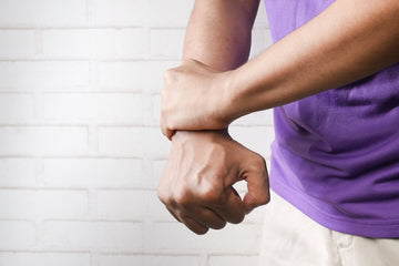 Person holding a sore knee with joint pain, considering capsaicin cream side effects