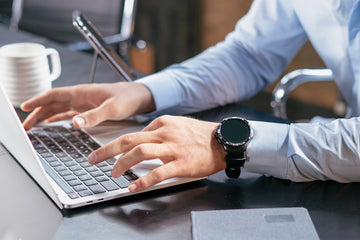 Office worker holding sore wrist at desk, carpal tunnel typing pain